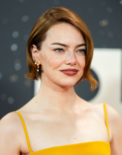 Emma Stone posing in a strappy yellow dress