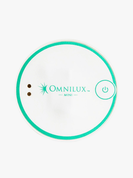 Omnilux Mini Blemish Eraser in oval shape in white and teal on light gray background
