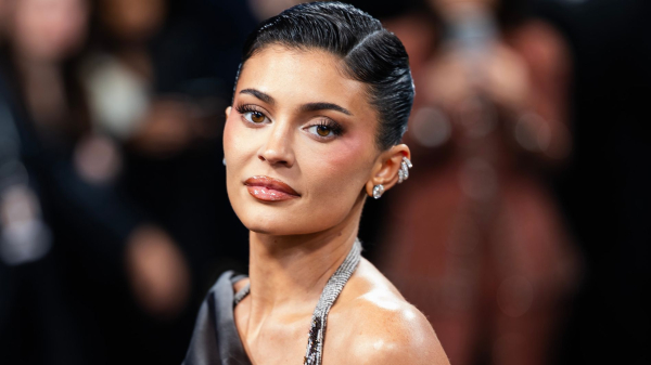 Kylie Jenner appears at the Met Gala in a gray halter gown. She wears her hair pulled up and back.